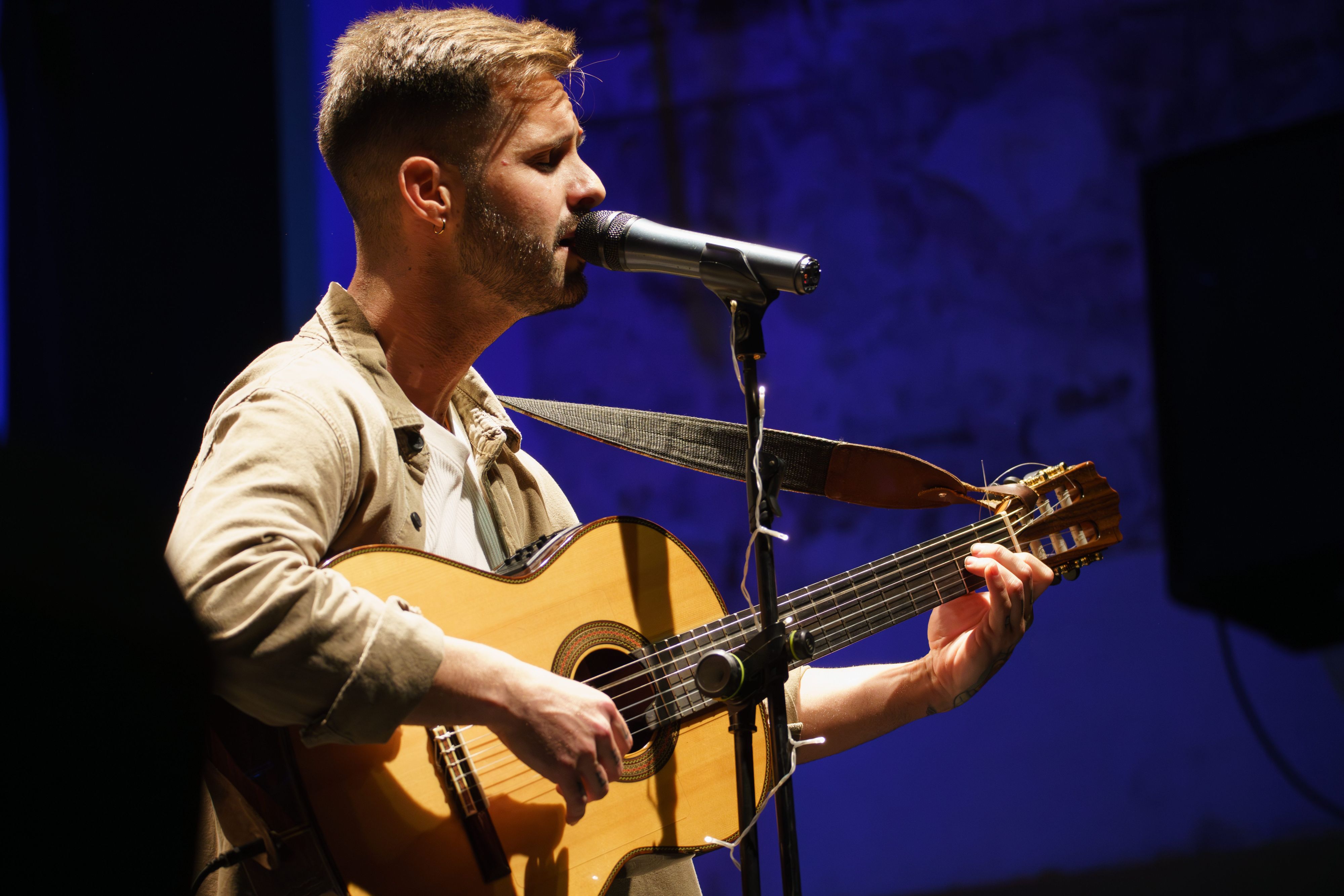 man playing acoustic guitar on stage