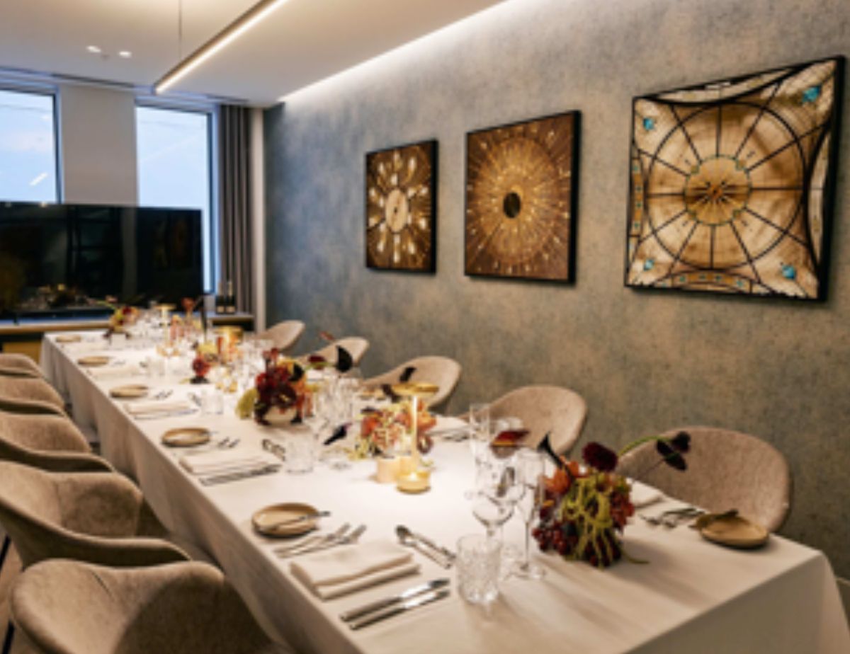 Elegant private dining room with long table and floral centerpieces.