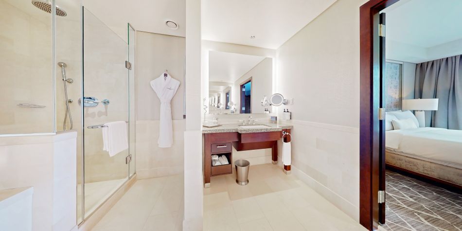 Ambassador Suite bathroom with a vanity, walk in shower, and luxurious amenities.