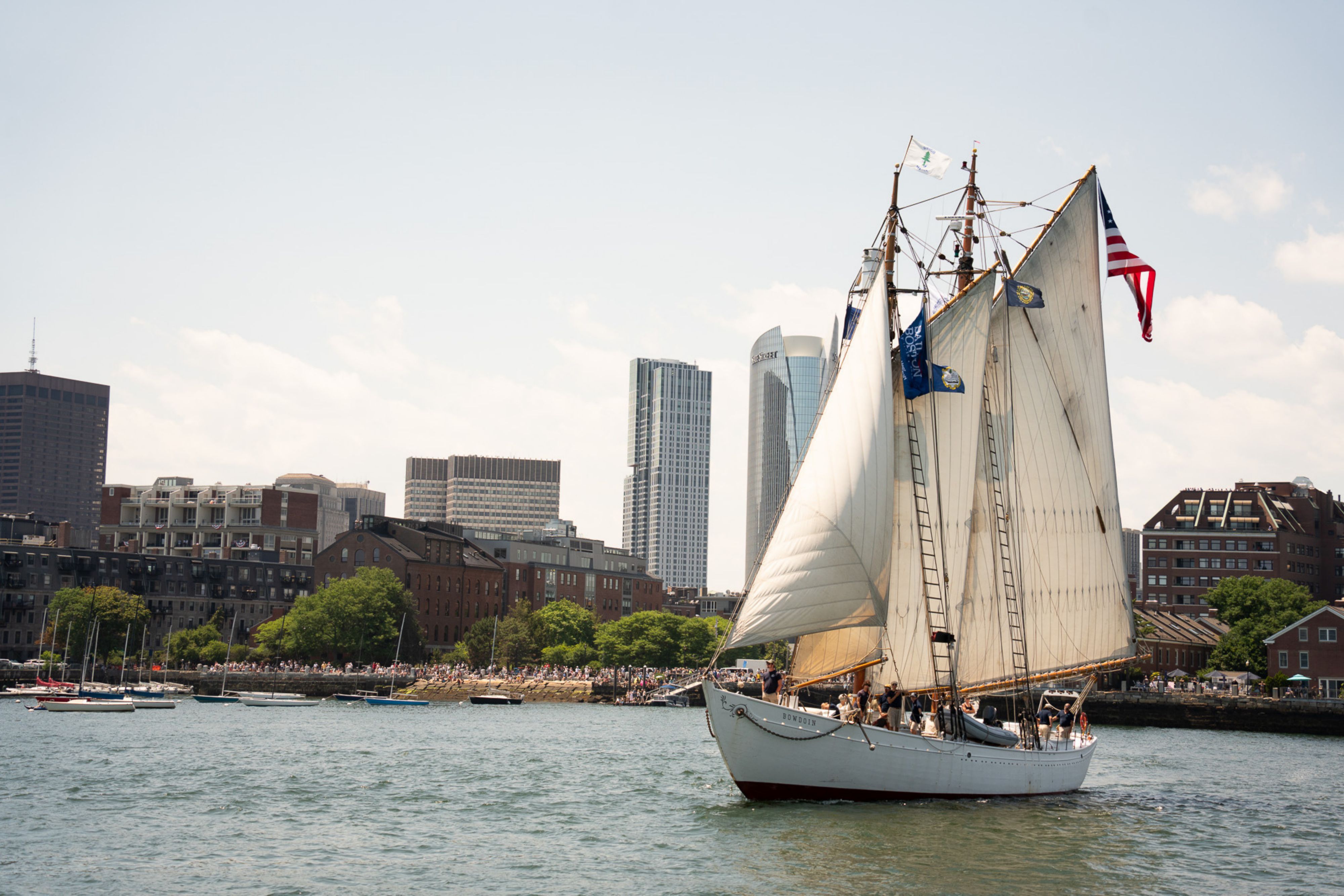 Historic schooner Roseway sailing on Boston Harbor with skyline.