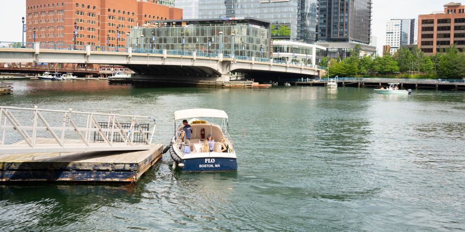 Water taxi with driver and guests leaving the dock.