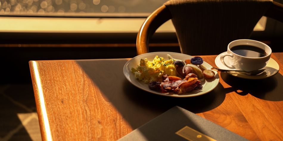 Breakfast plate and coffee beside a sunlit window at InterContinental Boston.