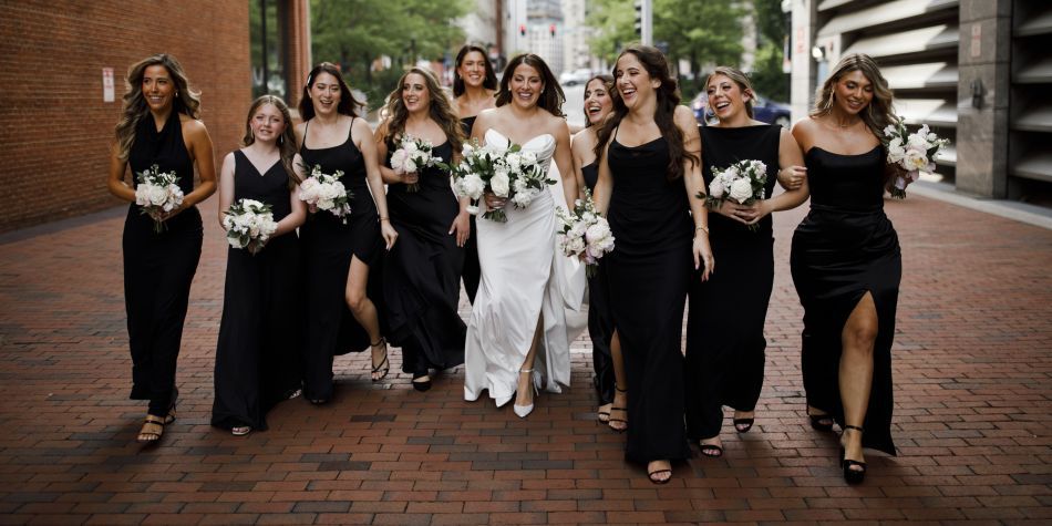 Bridal party in black dresses standing with the bride.