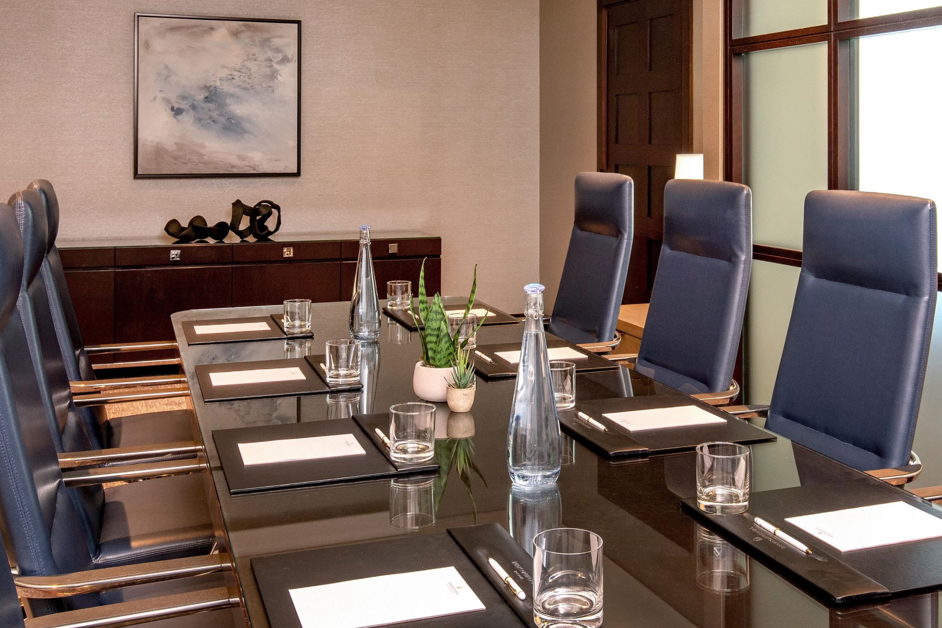 Club InterContinental boardroom set with leather chairs, notepads, and water service.