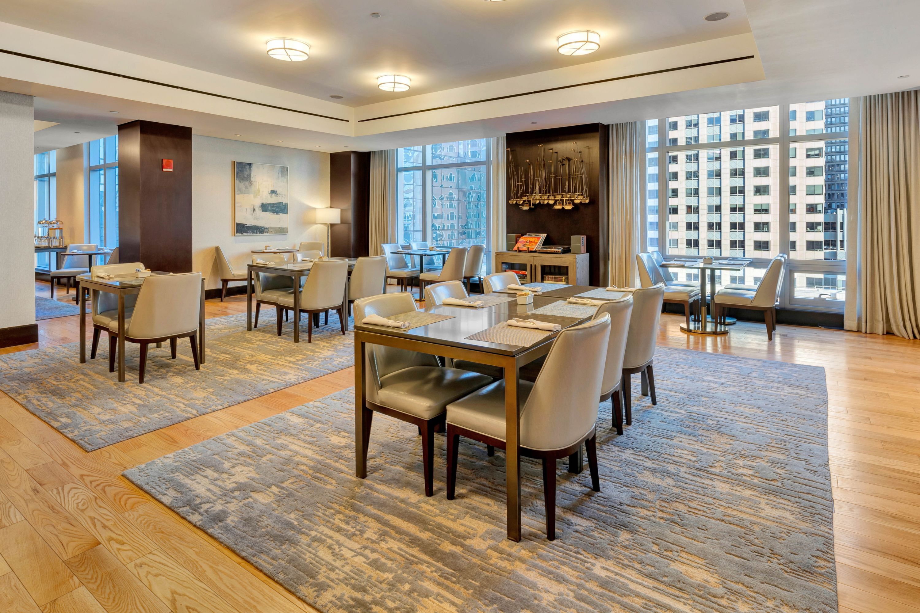 Club InterContinental dining area with table seating and floor-to-ceiling windows overlooking Boston.