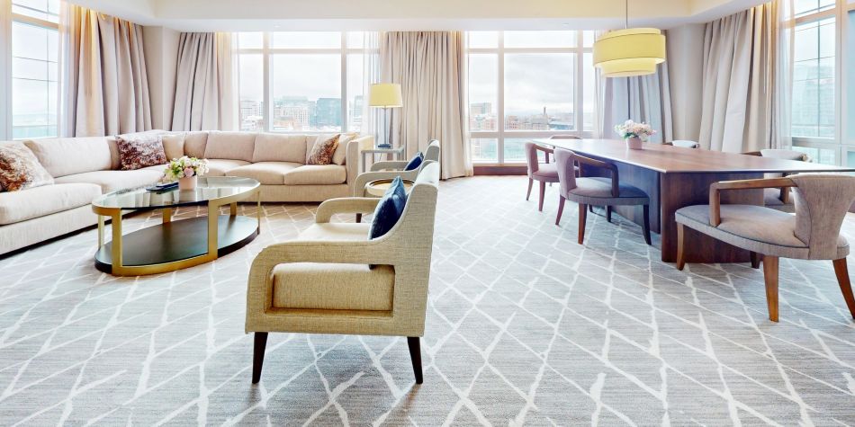 Club InterContinental suite living and dining area with floor-to-ceiling windows overlooking Boston Harbor.