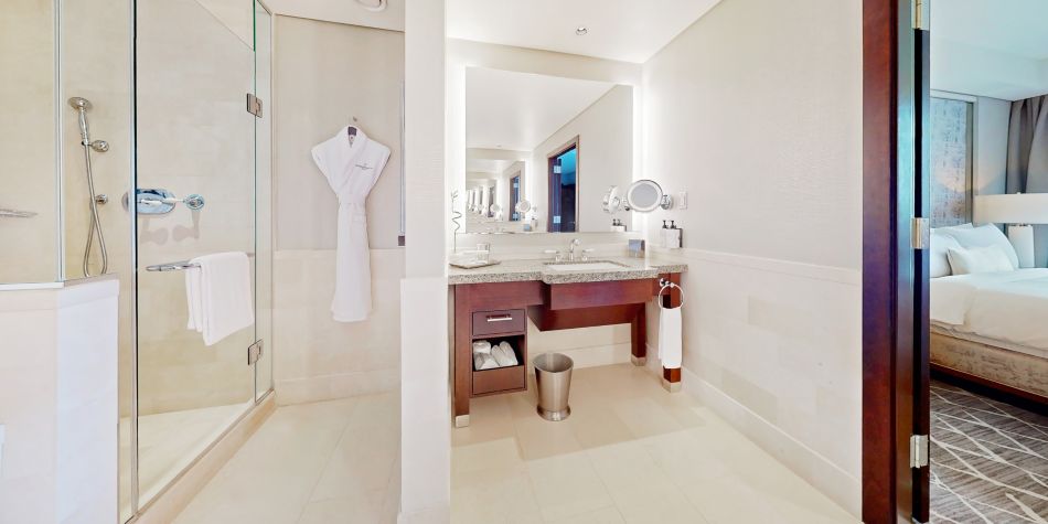 Modern suite bathroom with a walk-in shower, large mirror, and vanity.