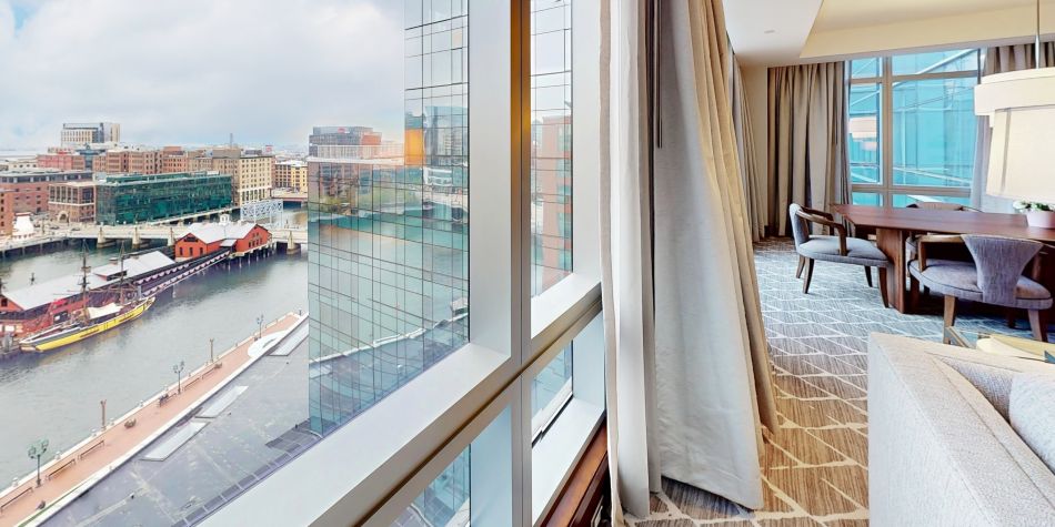 Club InterContinental suite overlooking Boston Harbor with large windows and a dining area.