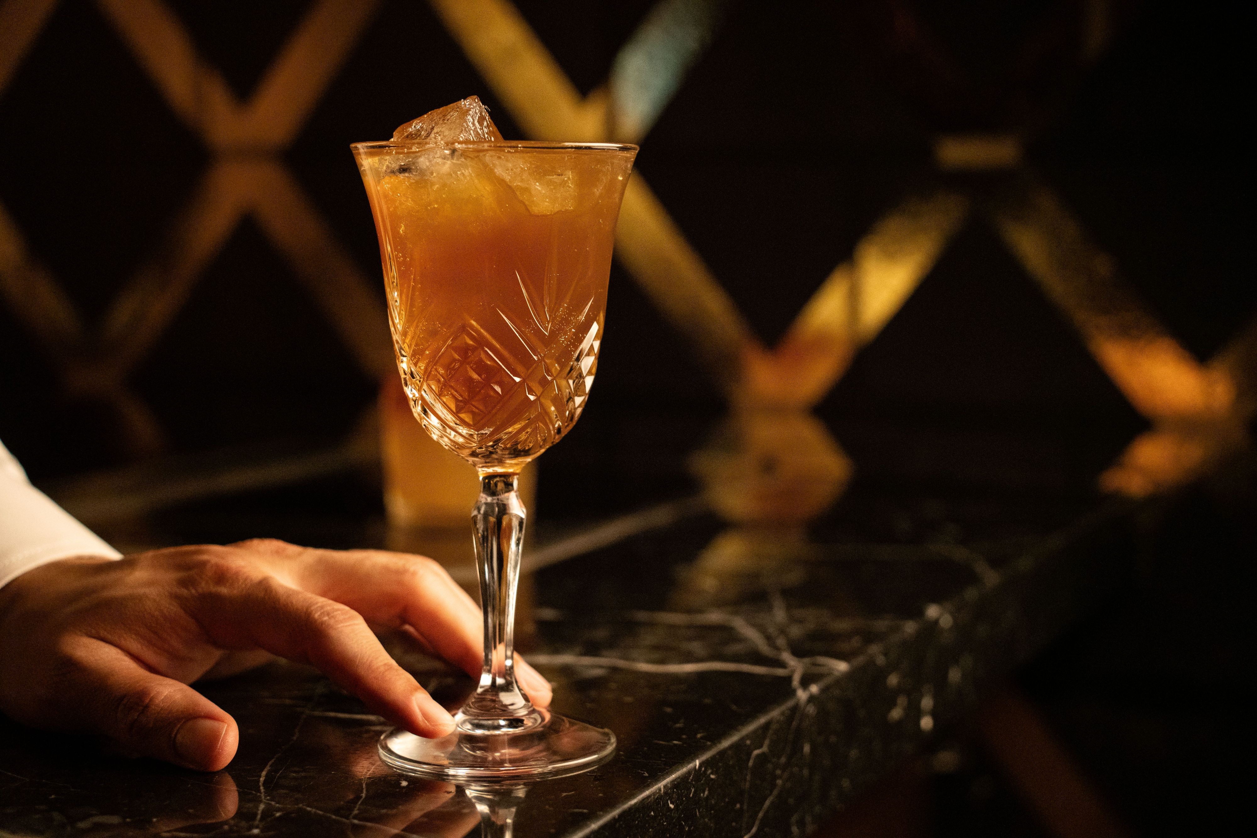 Bartender pushing forward a cocktail at Loyall.