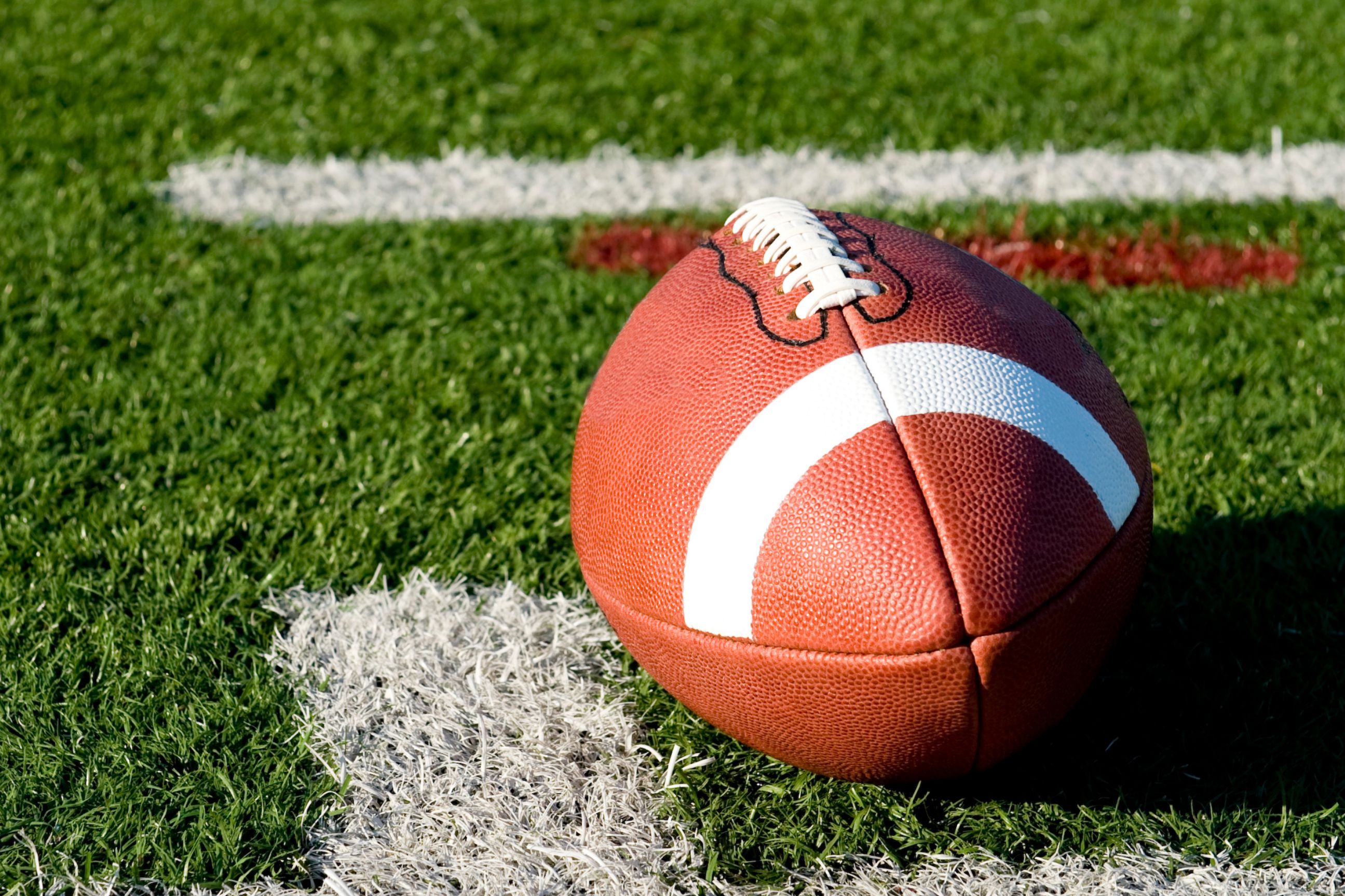 Football resting on a marked grass field.