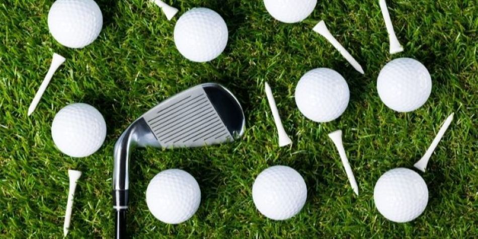 Golf club and tees on turf grass.
