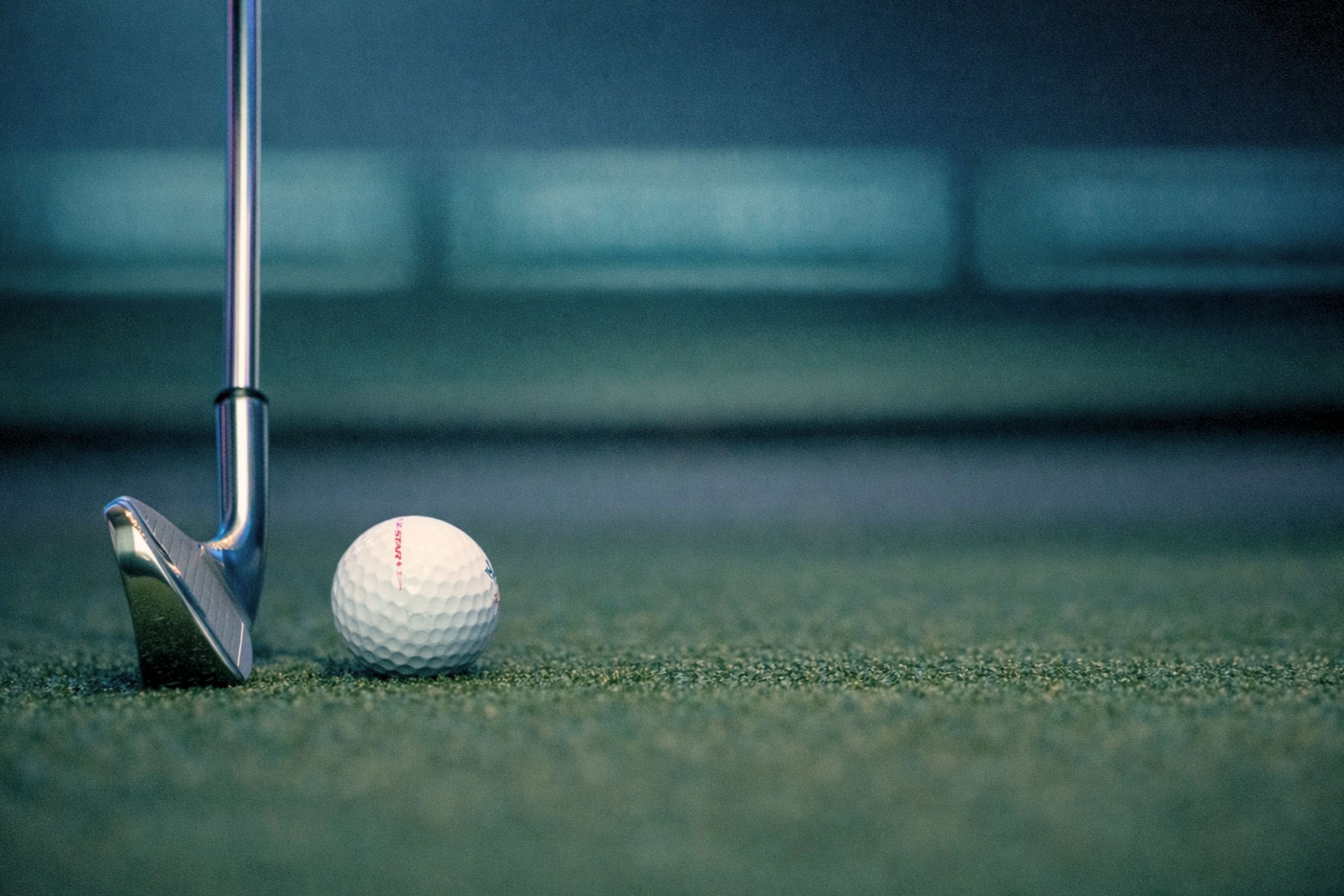 Golf club and ball on putting green