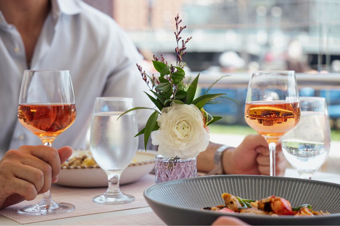Close up of dishes and rose as guests dine at IC Boston.