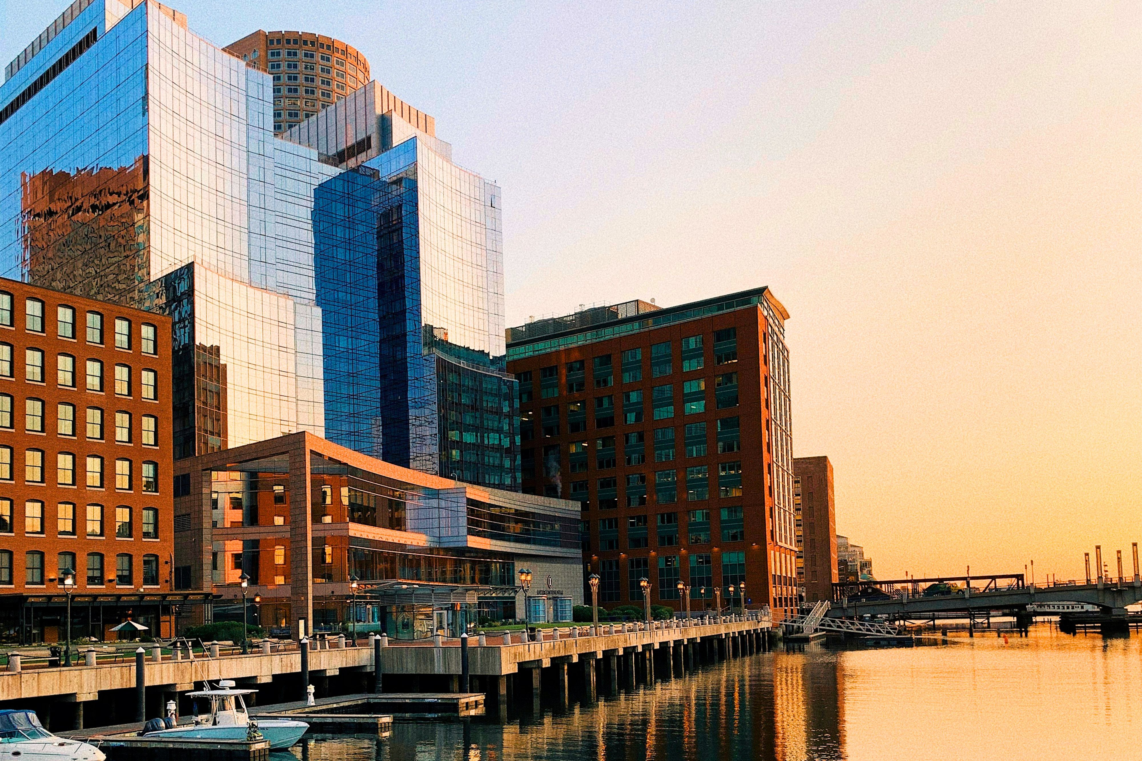 IC Boston waterfront skyline glowing at golden hour near the Seaport.