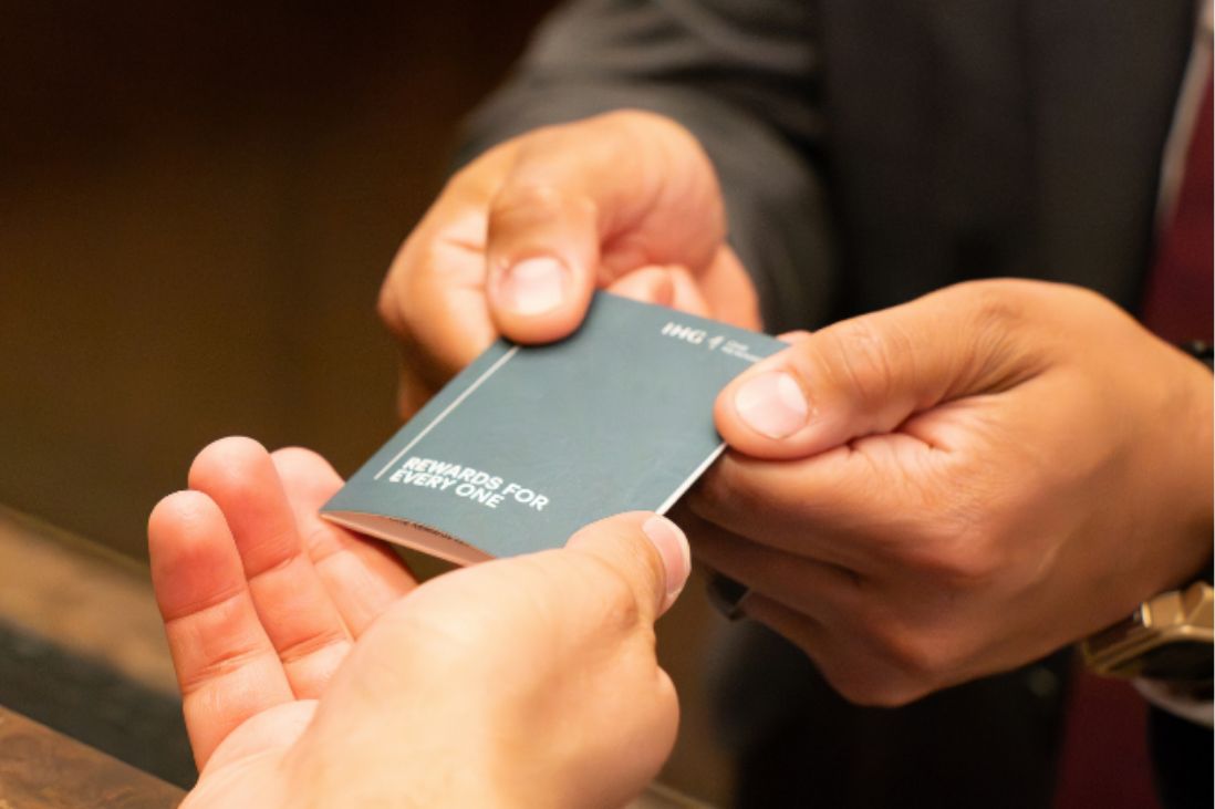 Close up of staff handing a guest a hotel room key card.