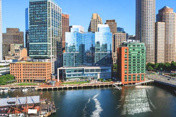 Aerial view of InterContinental Boston on the waterfront, surrounded by downtown skyscrapers.