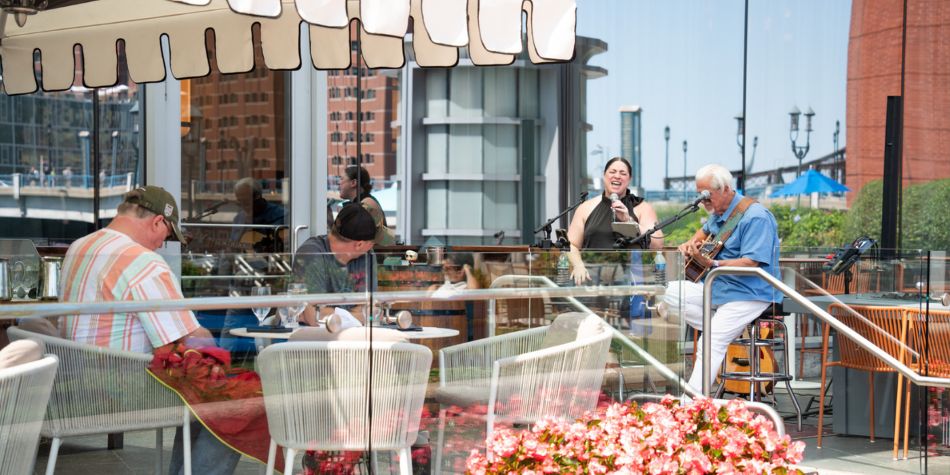 Performers doing a live show in outdoor dining area.