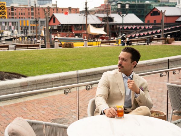 Man enjoying a cocktail by the harbor at InterContinental Boston.