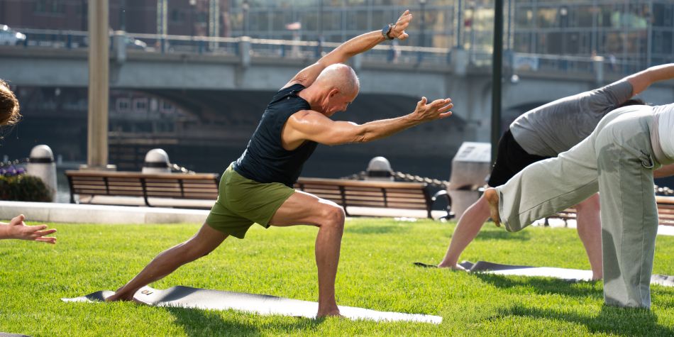 Man in warrior 2 variation yoga pose.