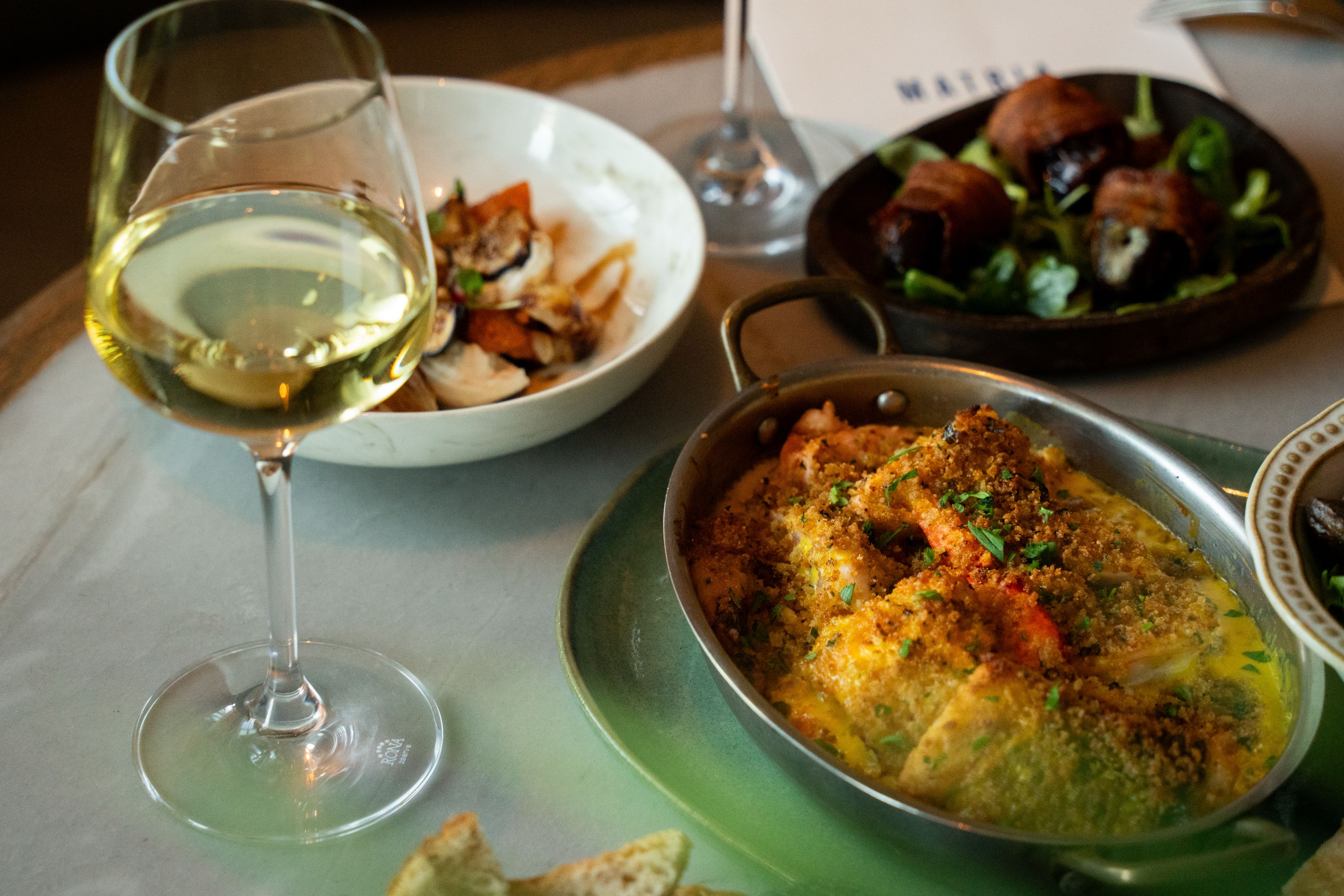 Seafood dishes and white wine served at InterContinental Boston Matria.