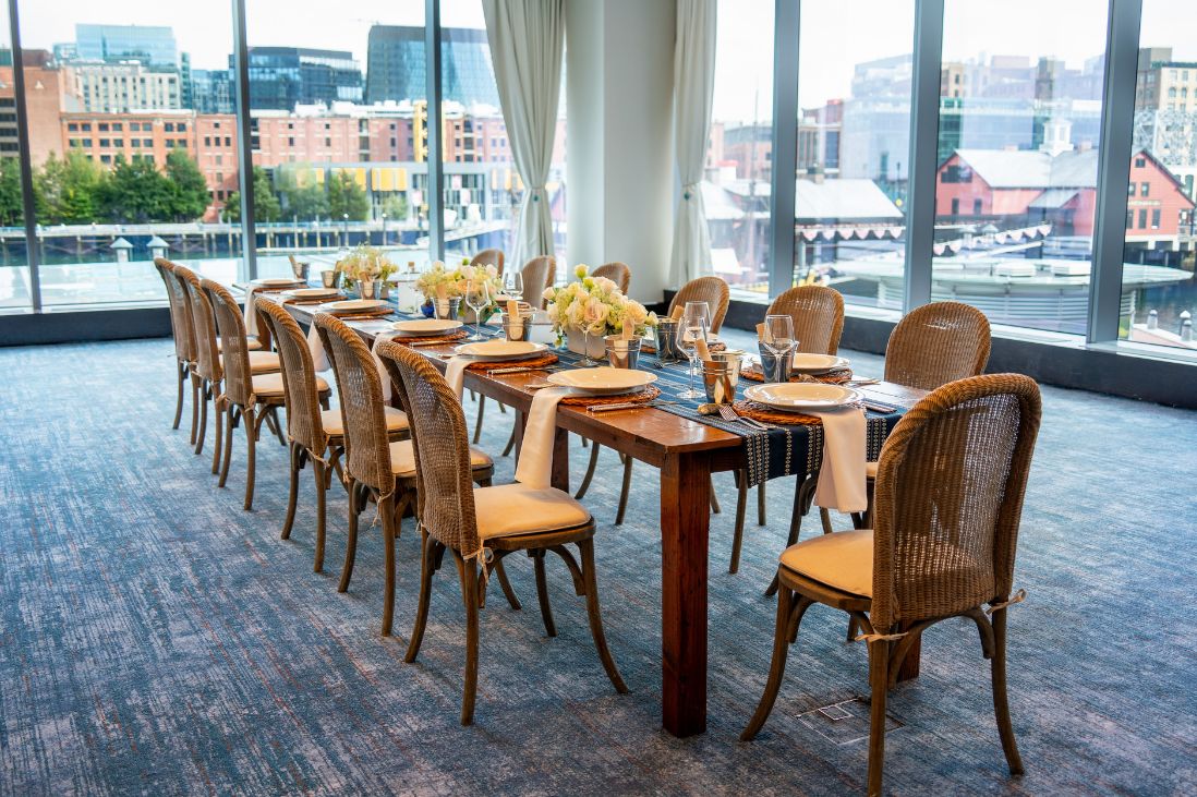 Private dining room with a table set for 13 guets with flowers and place settings.