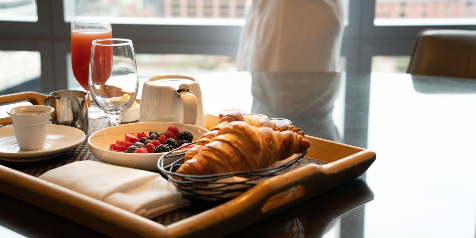 In-room breakfast with berries and croissants by the window.