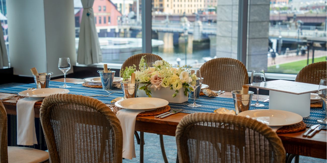 Table set for a dining event with a floral centerpiece, place settings and menus.