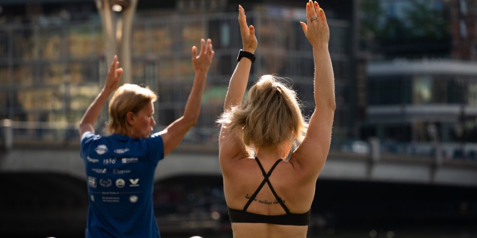Two women in warrior 1 pose.