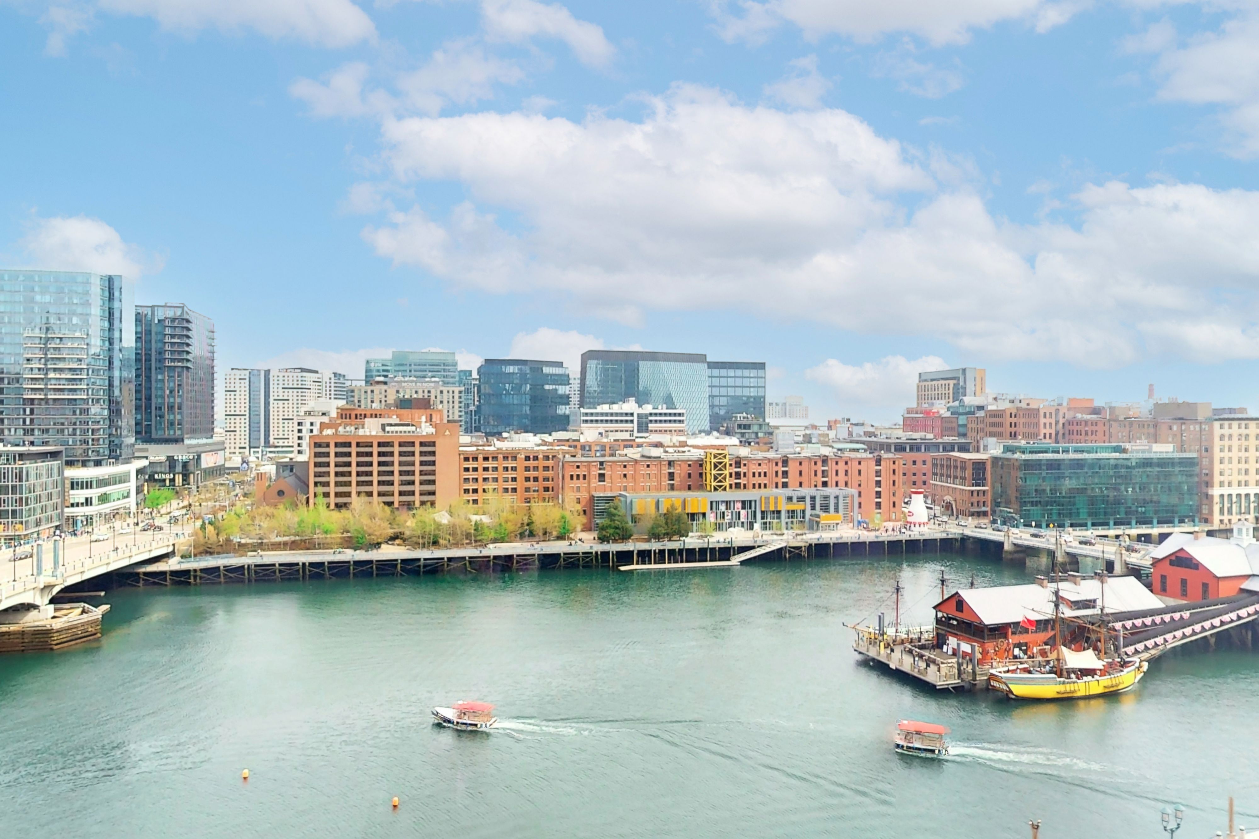 Boston Harbor waterfront with historic ship and modern skyline.