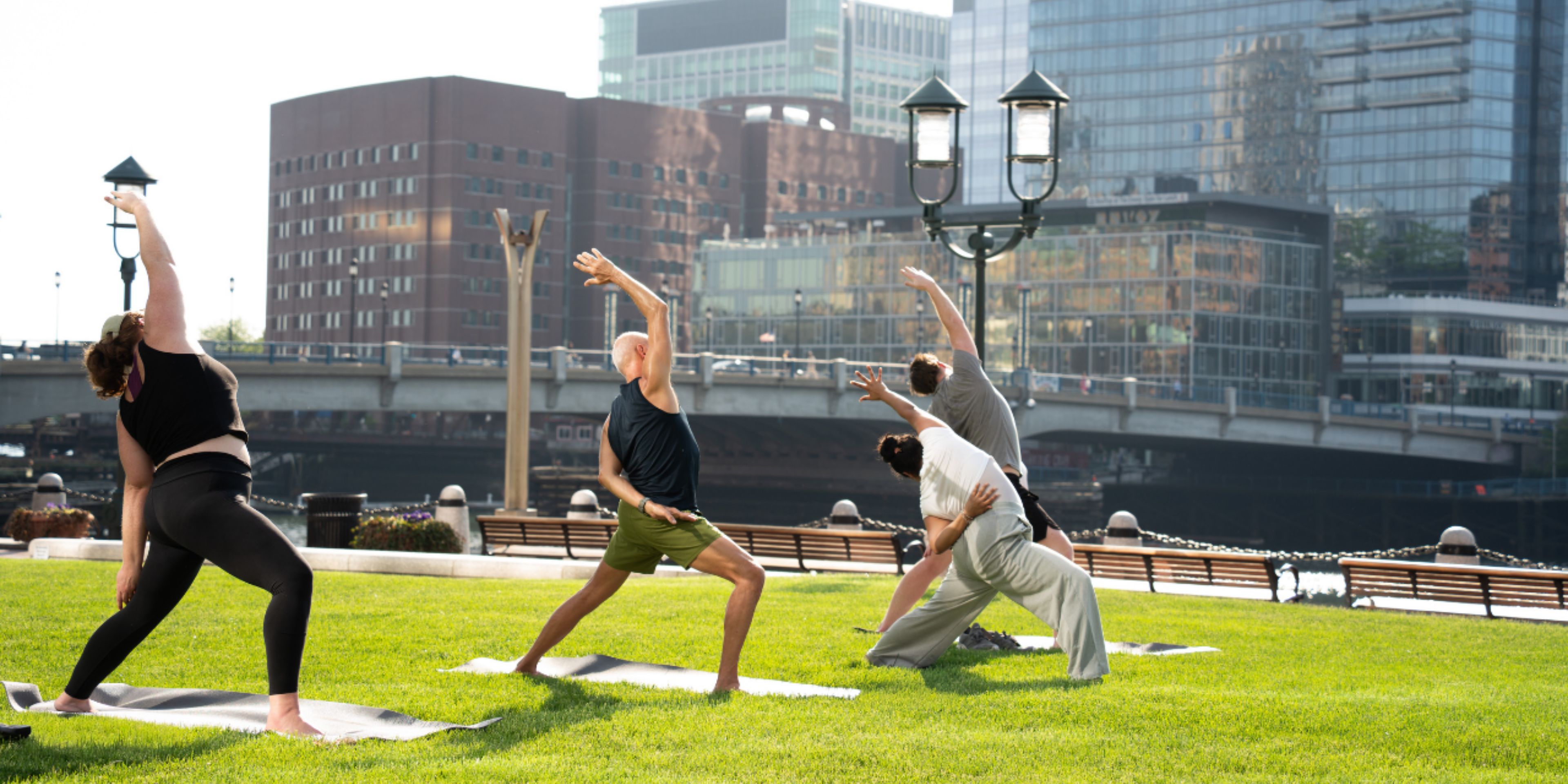 Guests participating in waterfront yoga on the lawn at InterContinental Boston. 