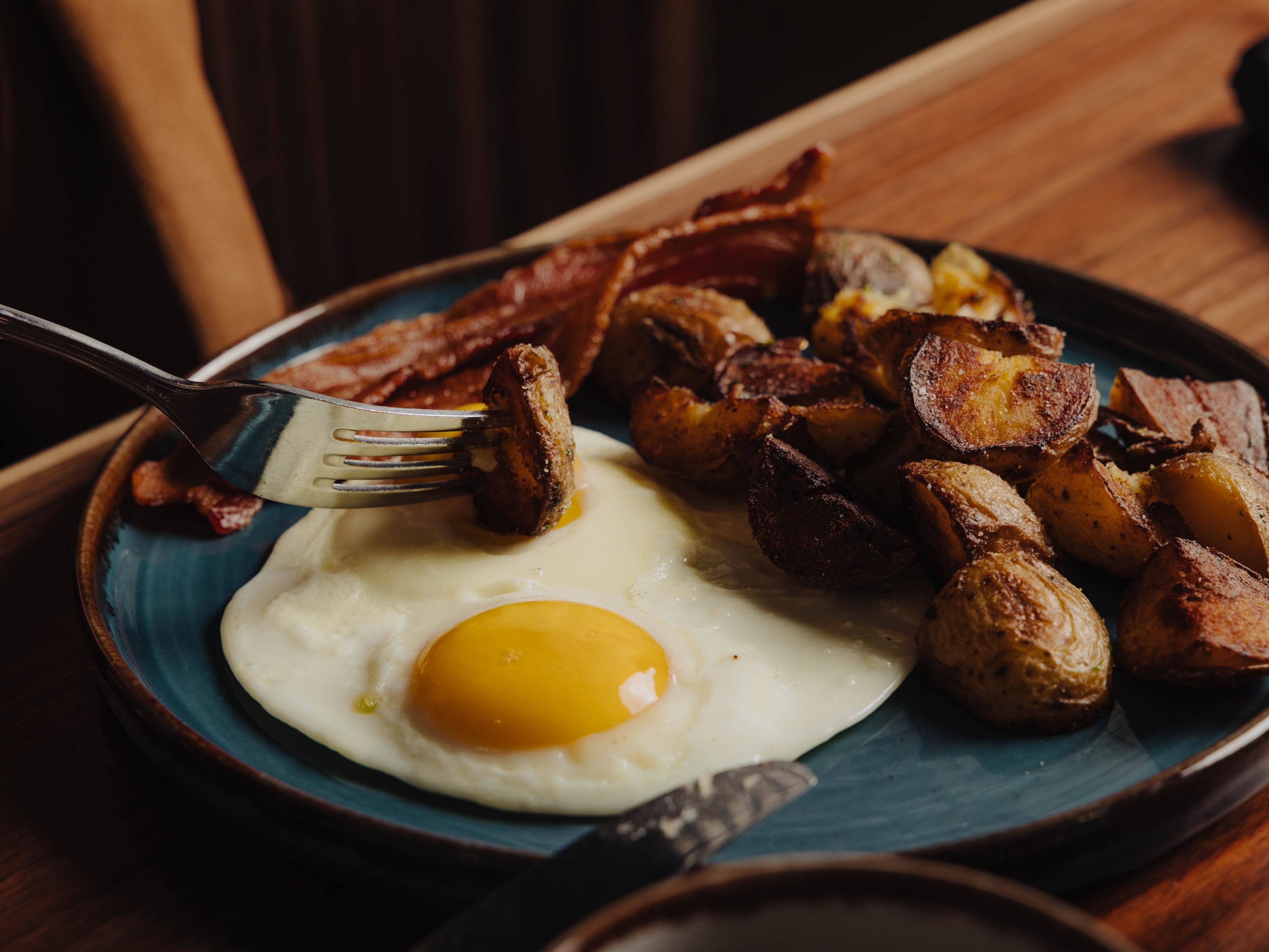 breakfast photo of potatoes, bacon and eggs