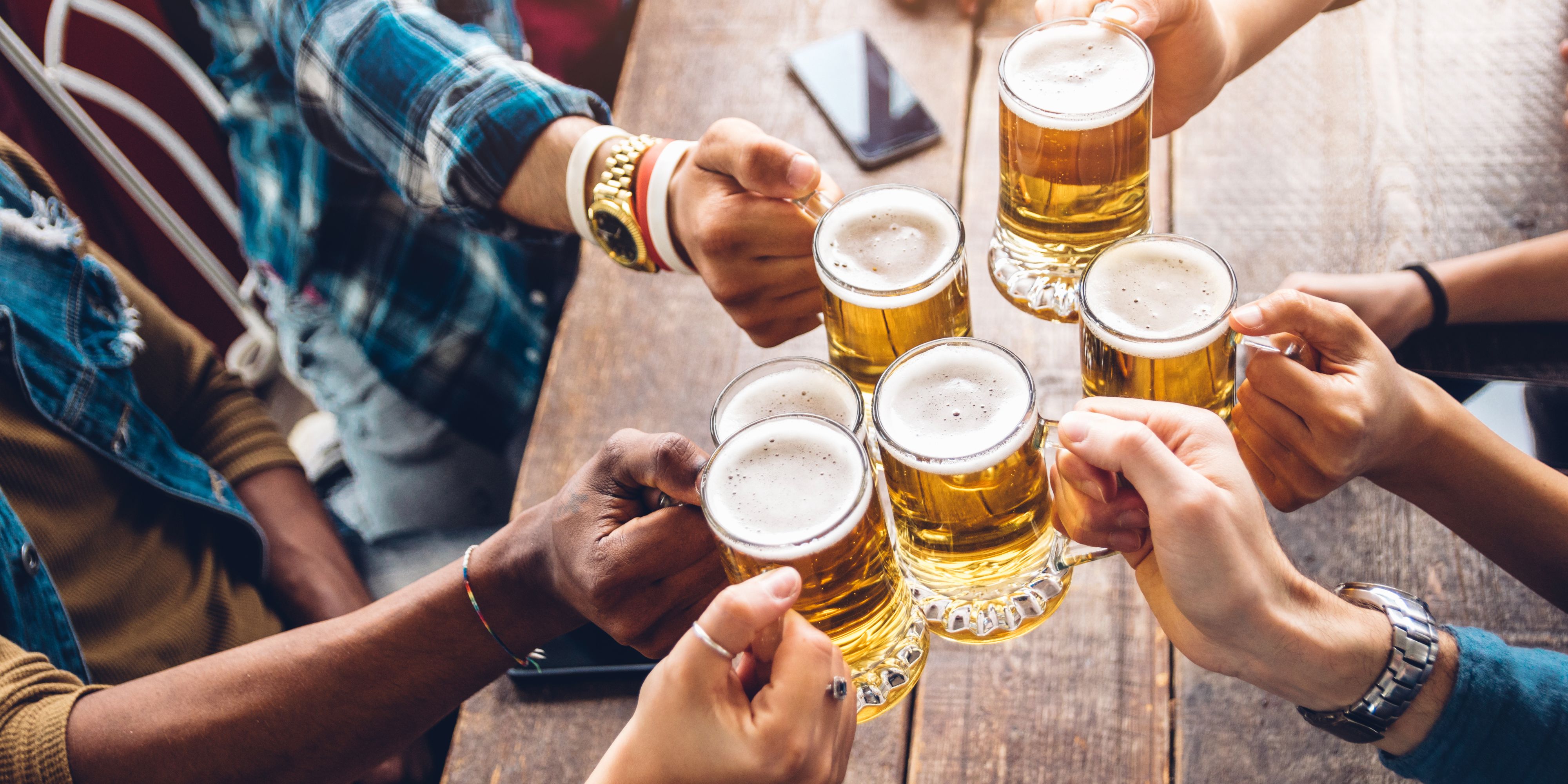 Friends toasting with beers at brewery.