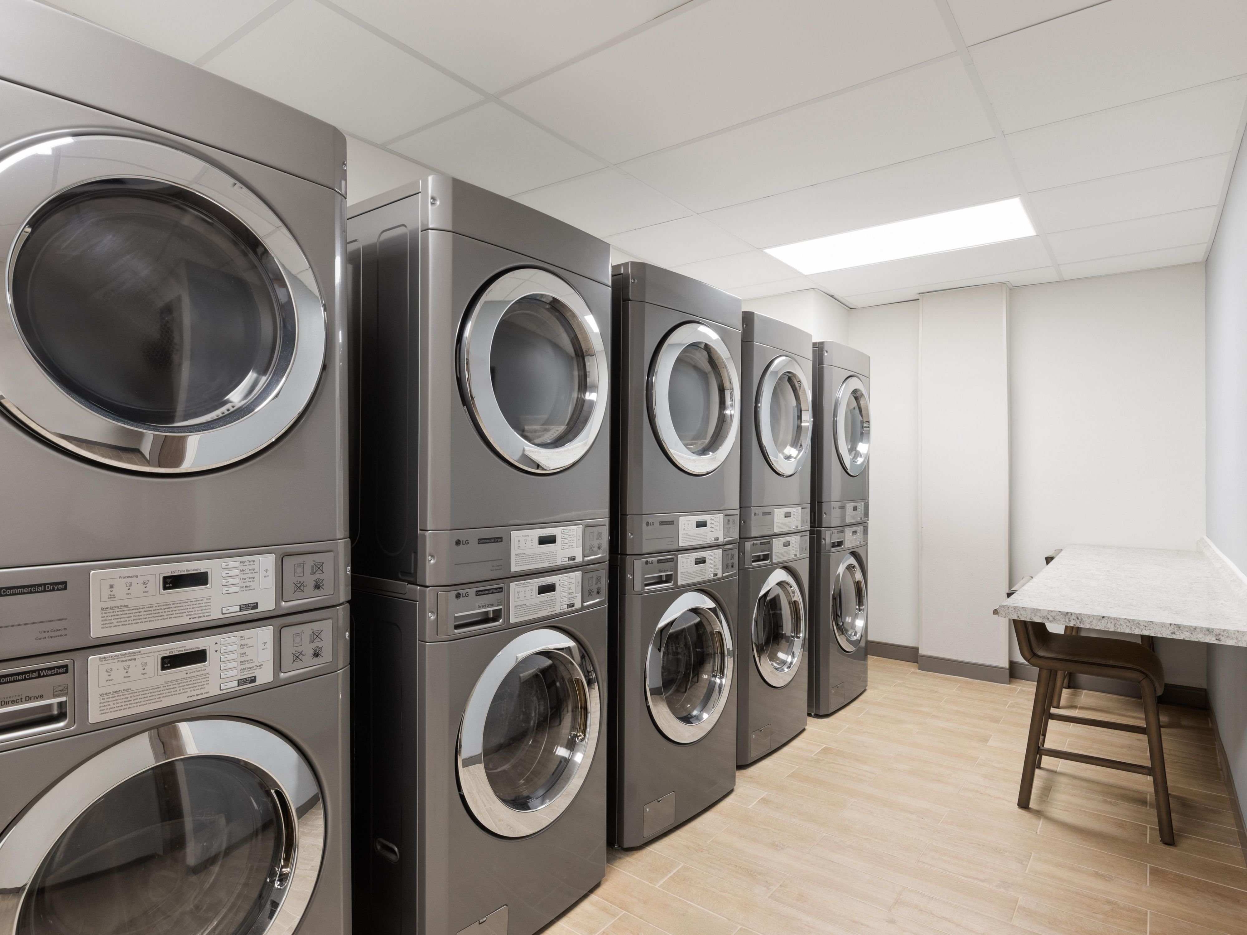 Guest laundry area with washers, dryers, and folding table