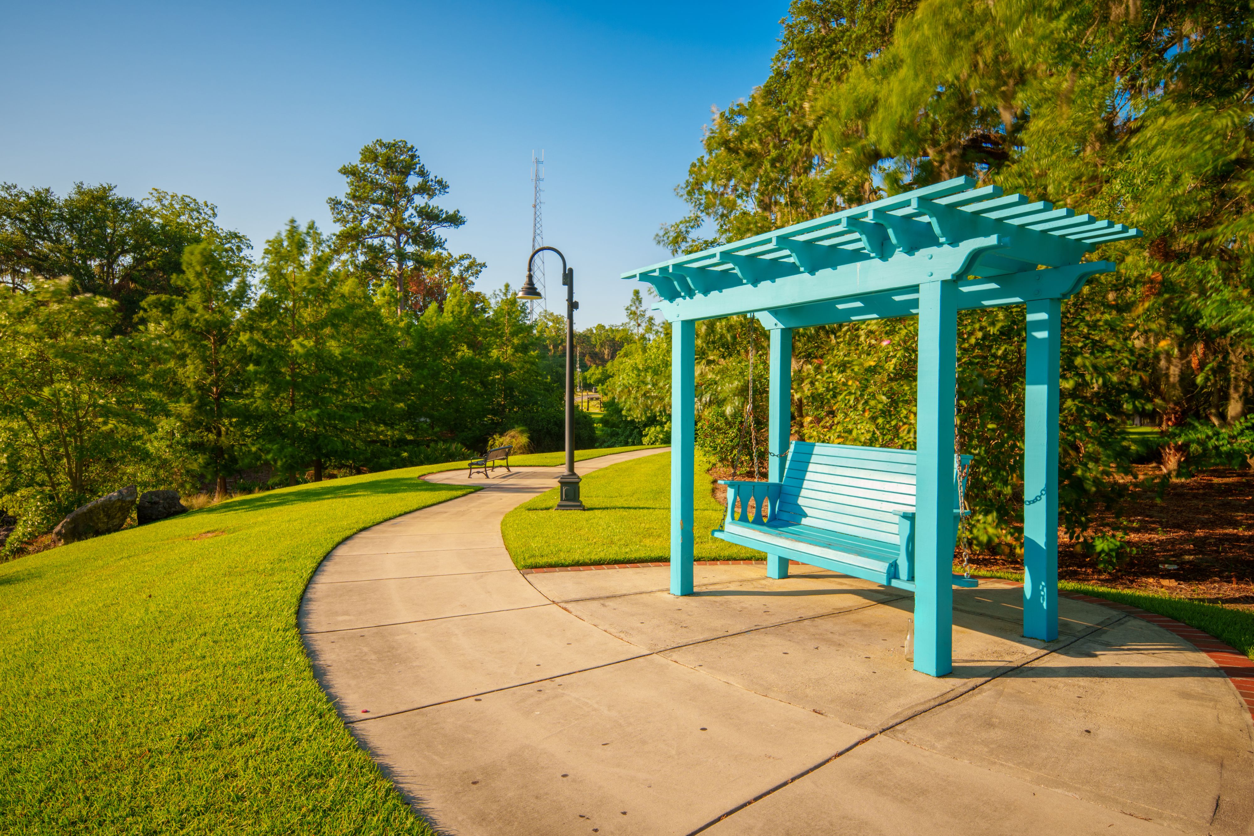 A swinging bench among the walking trail at Cascades Park.