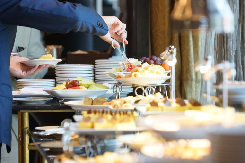 Person enjoying small dishes provided by catering