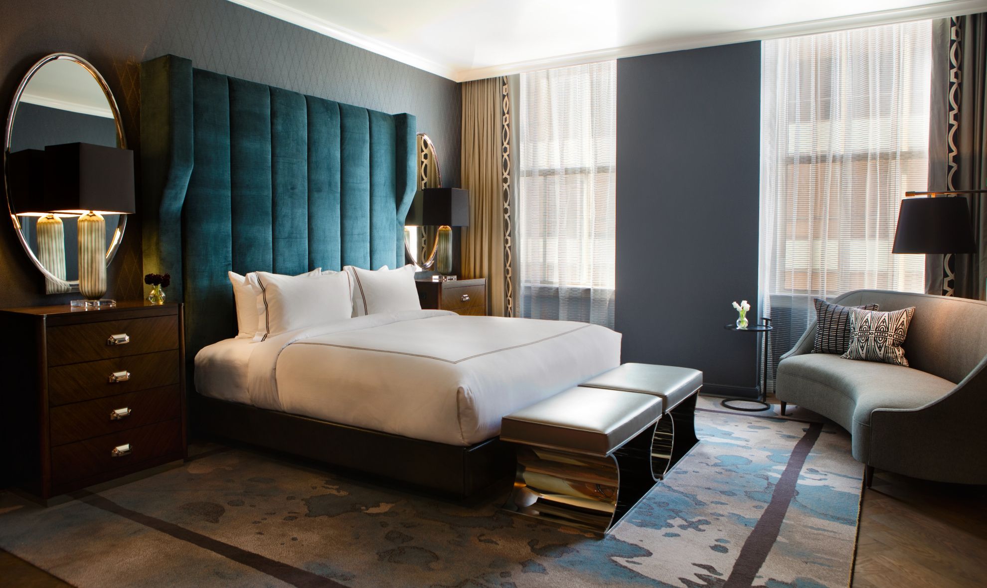 Plush jewel toned grand guestroom with large windows
