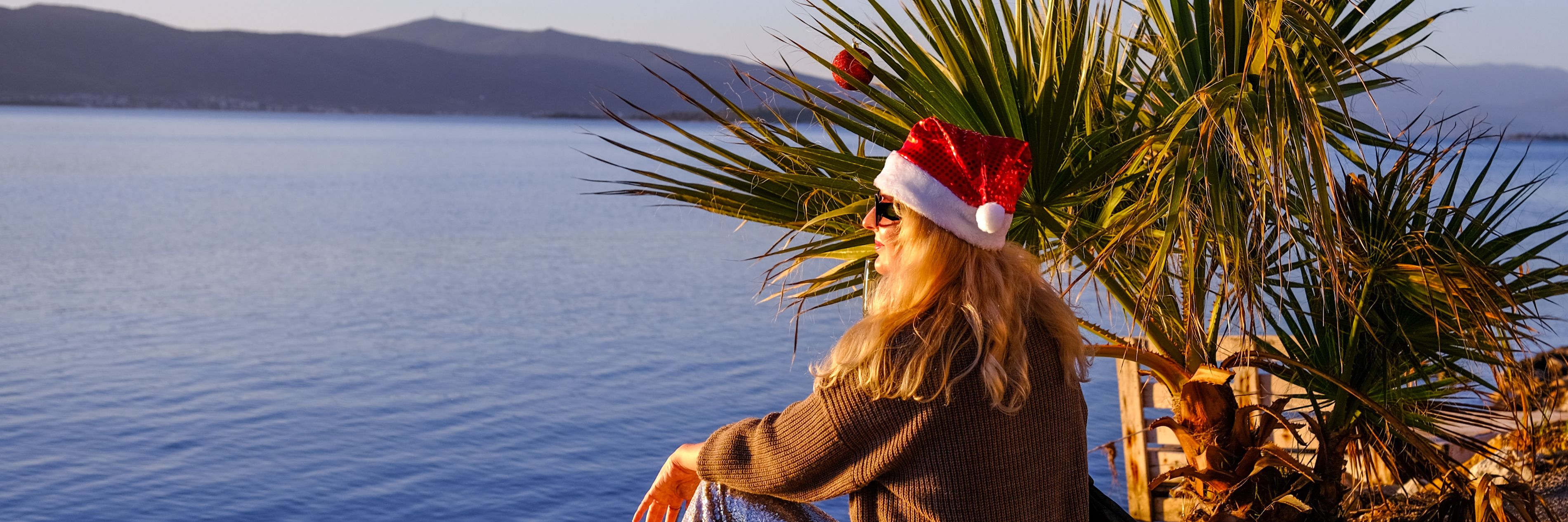 Woman sitting by the ocean looking at island surroundings