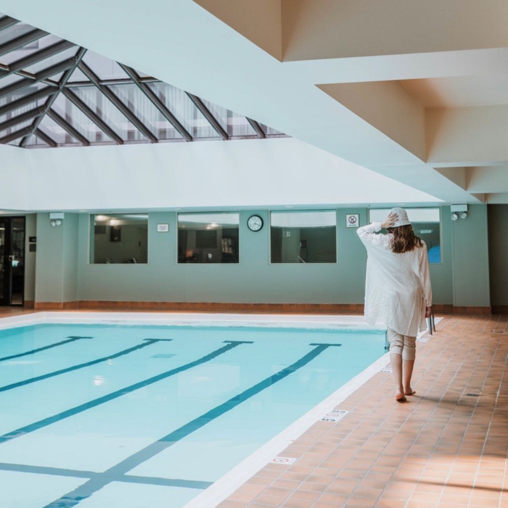 Woman walking by indoor pool