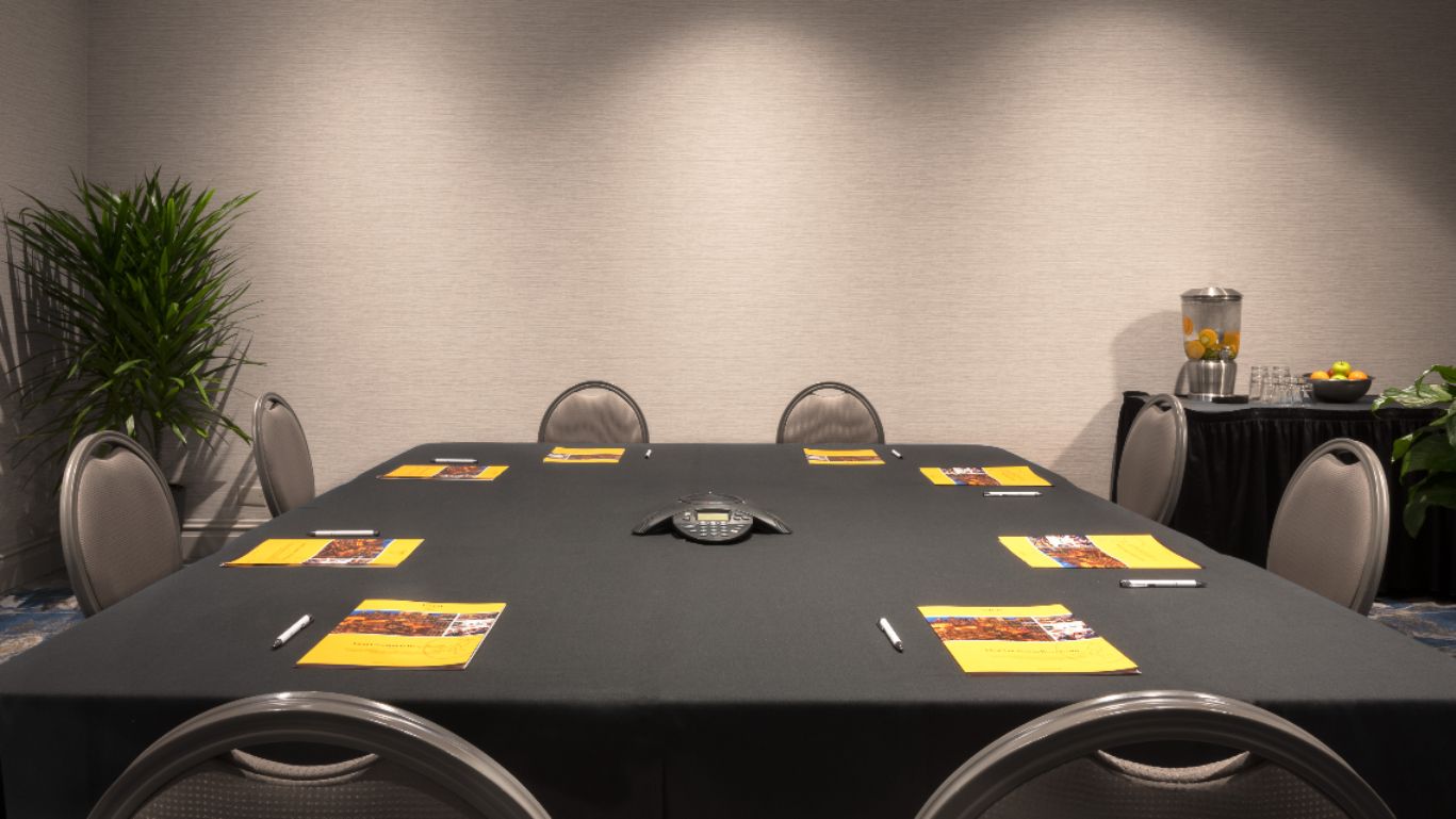 Large square table with conference phone in the center 