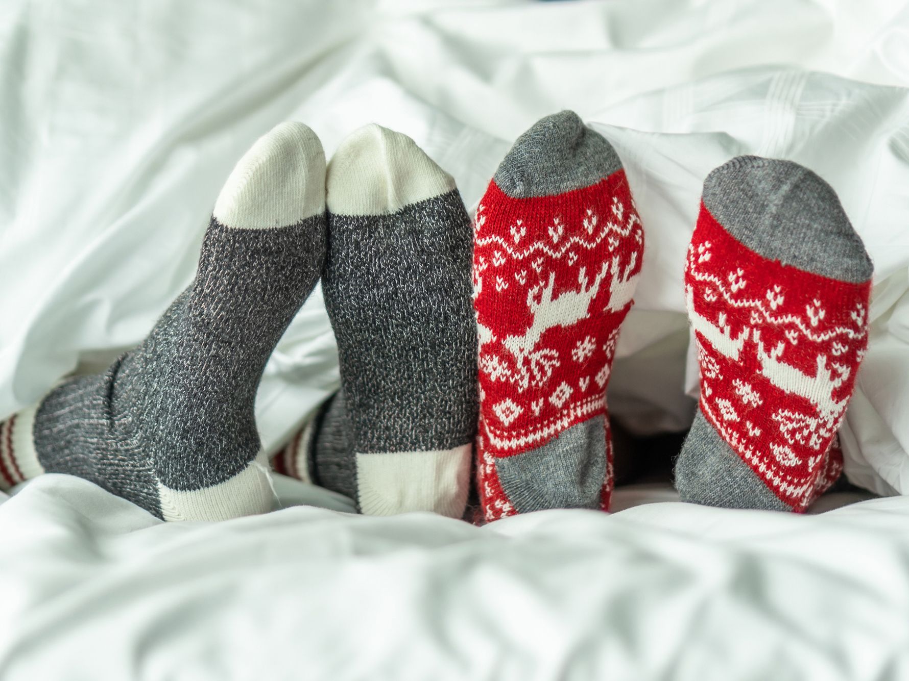 Christmas socks on feet in a bed