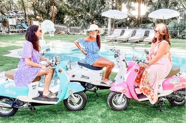 Three woman sitting on scooters.
