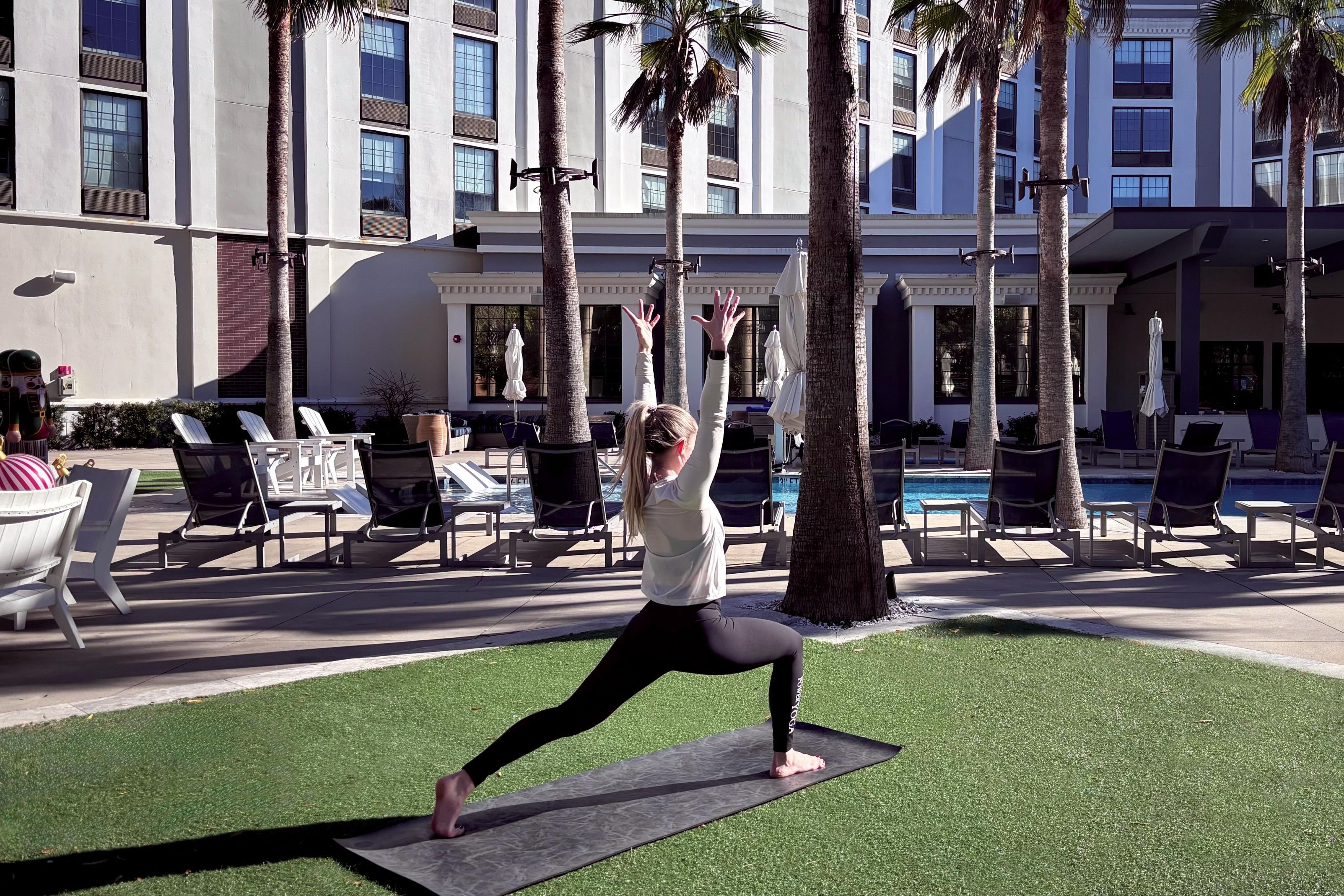 Woman doing a yoga pose on the lawn.