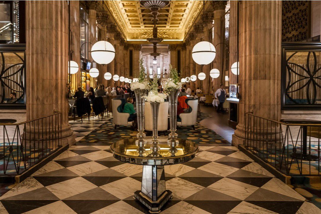 Elegant dining room with checkered floors and chandeliers.