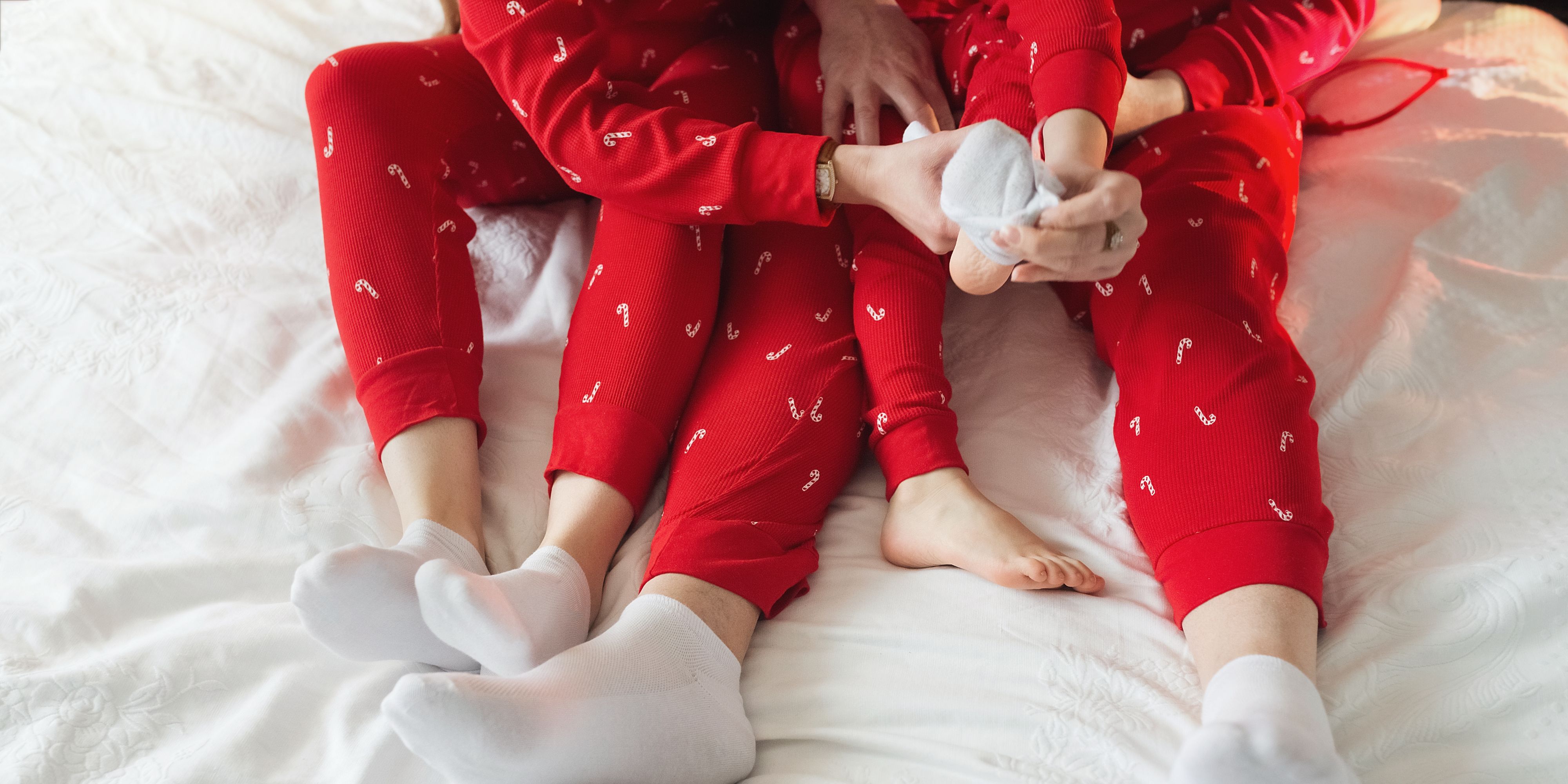 Family in Christmas pajamas on bed