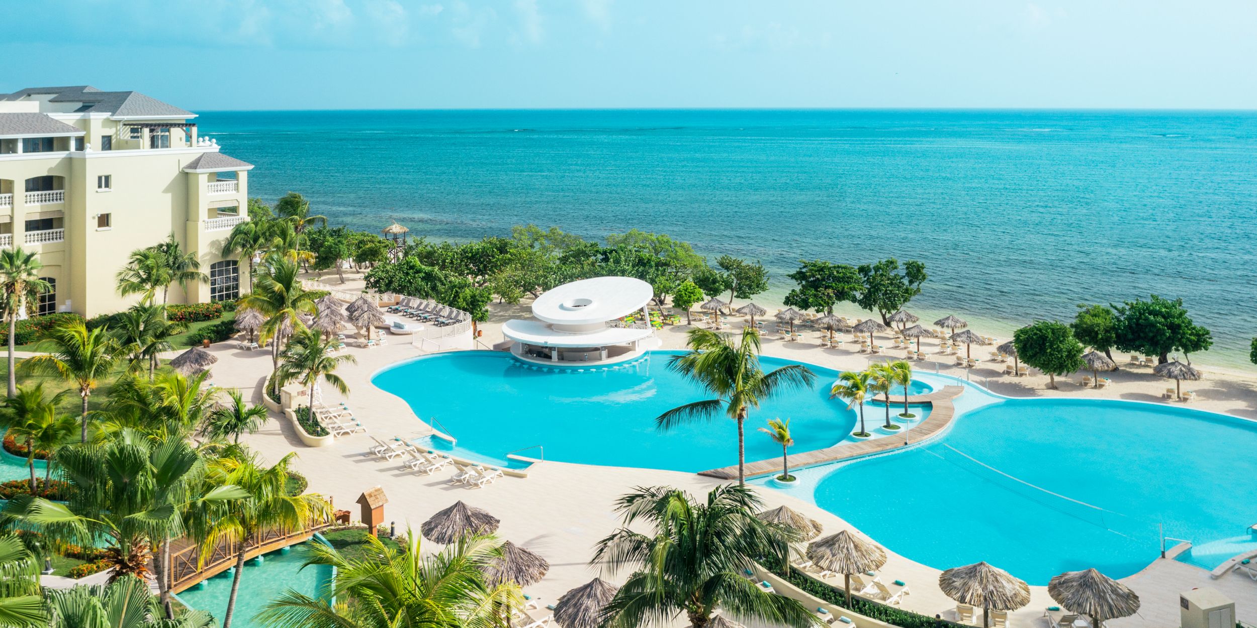 Beachfront resort with lagoon-style pools, palm trees, and ocean views. 