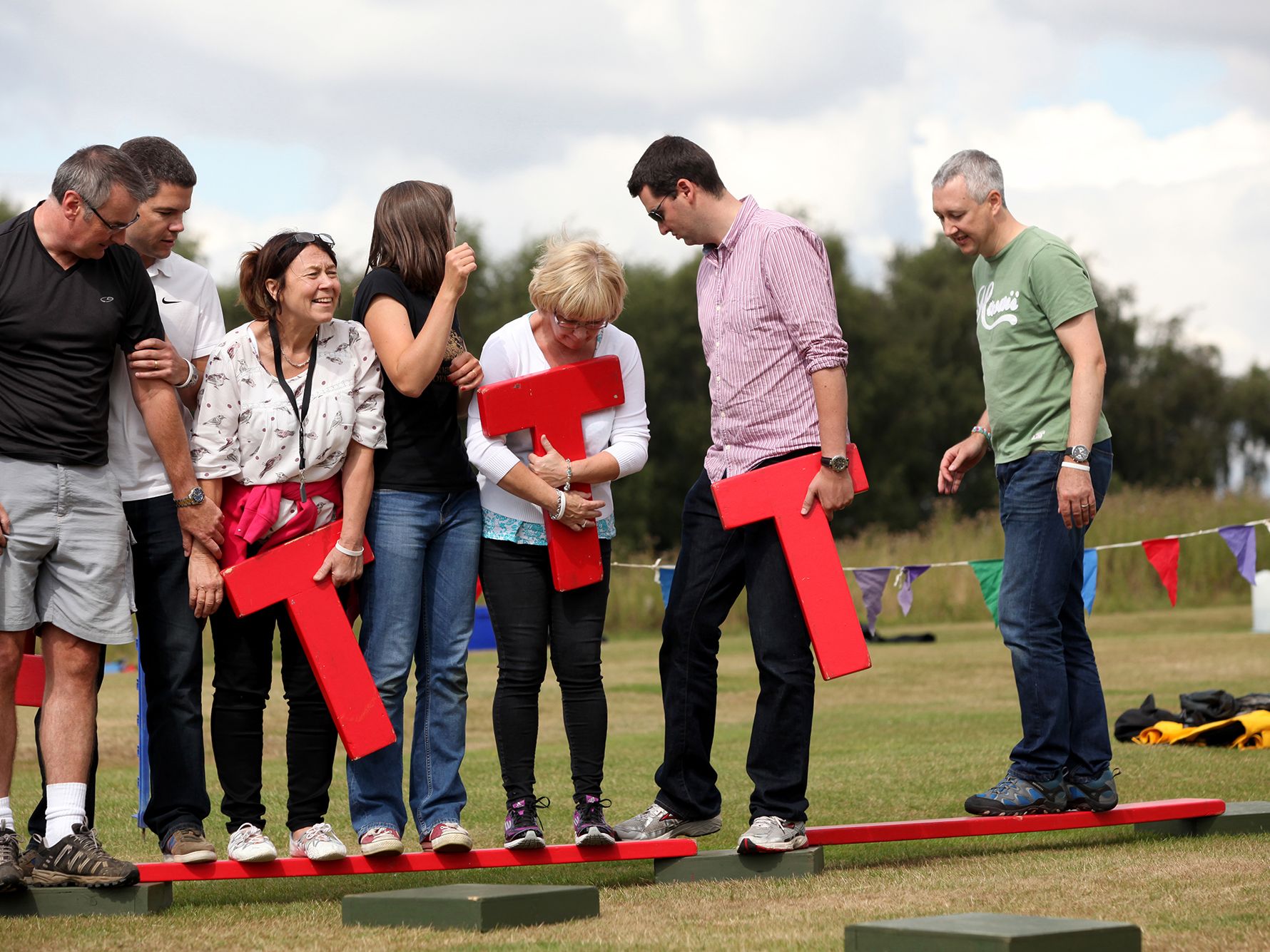 People playing game, holding the letter T, team building