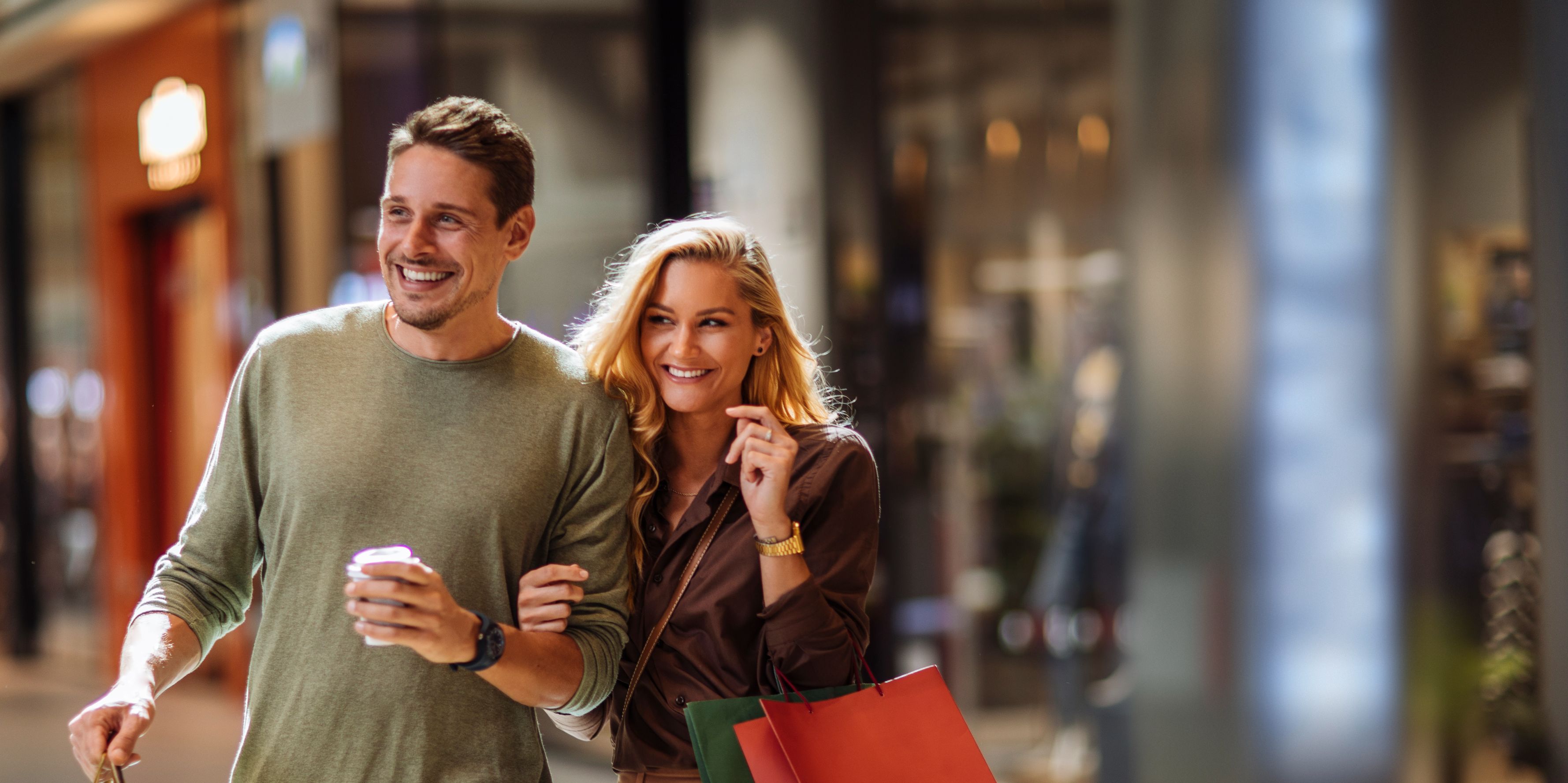 Couple walking through the mall with shopping bags.