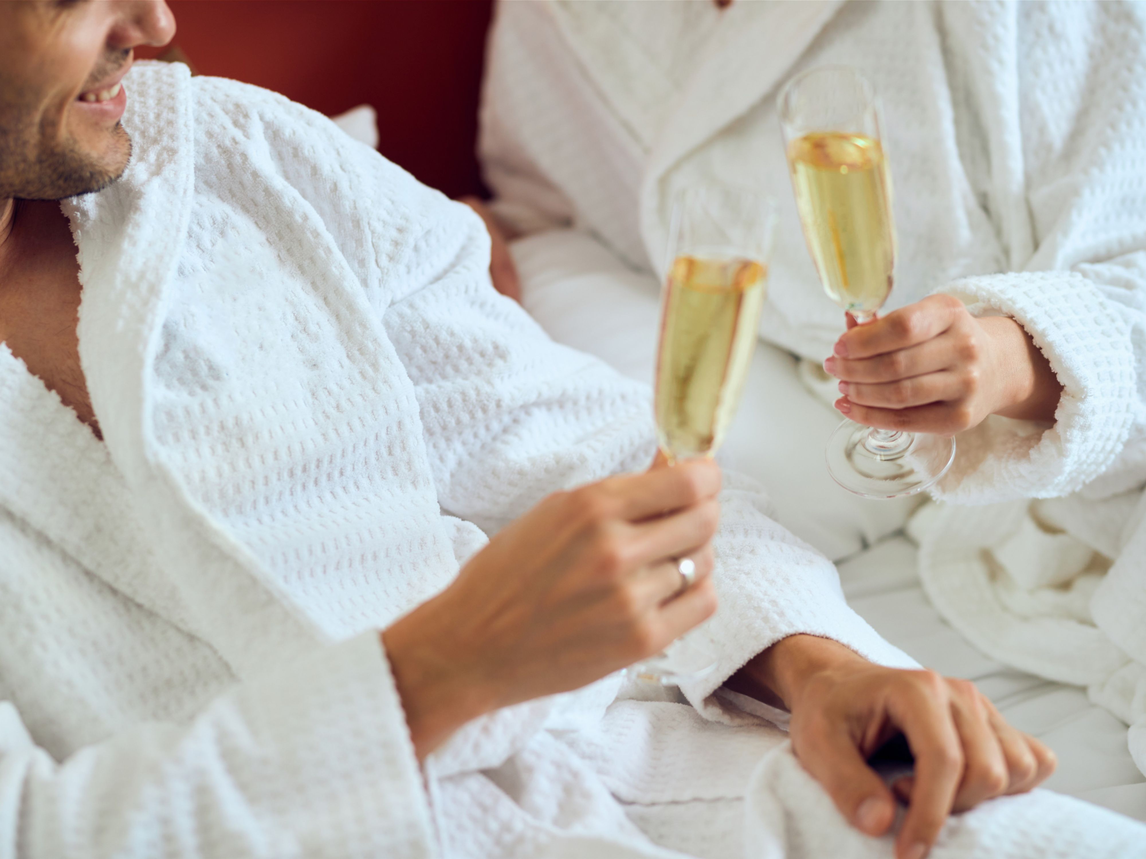 Couple toasting sparkling wine in bed