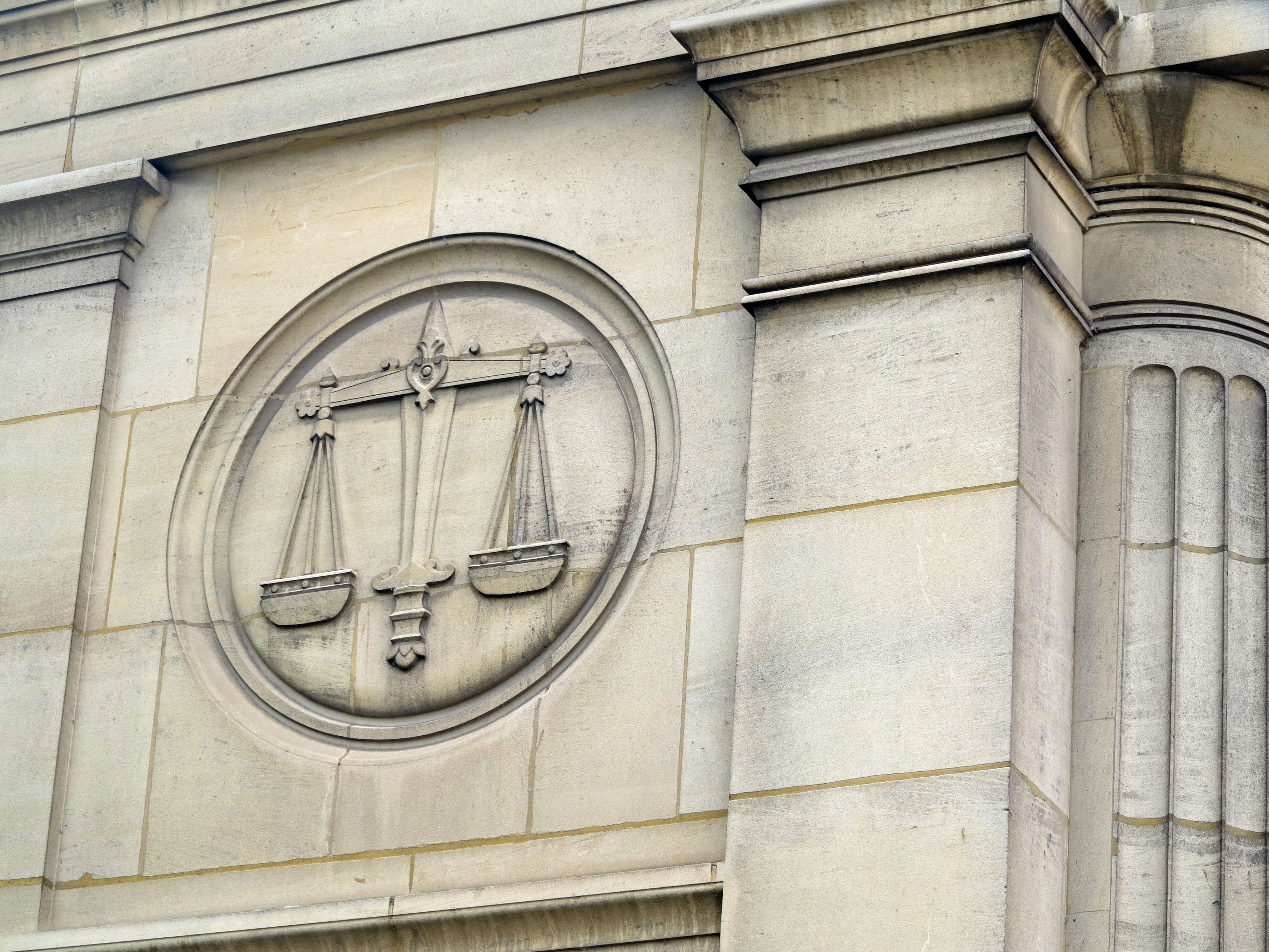 Courthouse building with gavel and scales engraving.