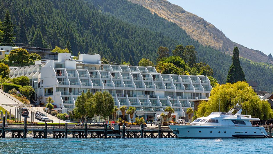 Exterior facade of Crowne Plaza Queenstown hotel building with stunning panoramic views of The Remarkables mountain range and Lake Wakatipu